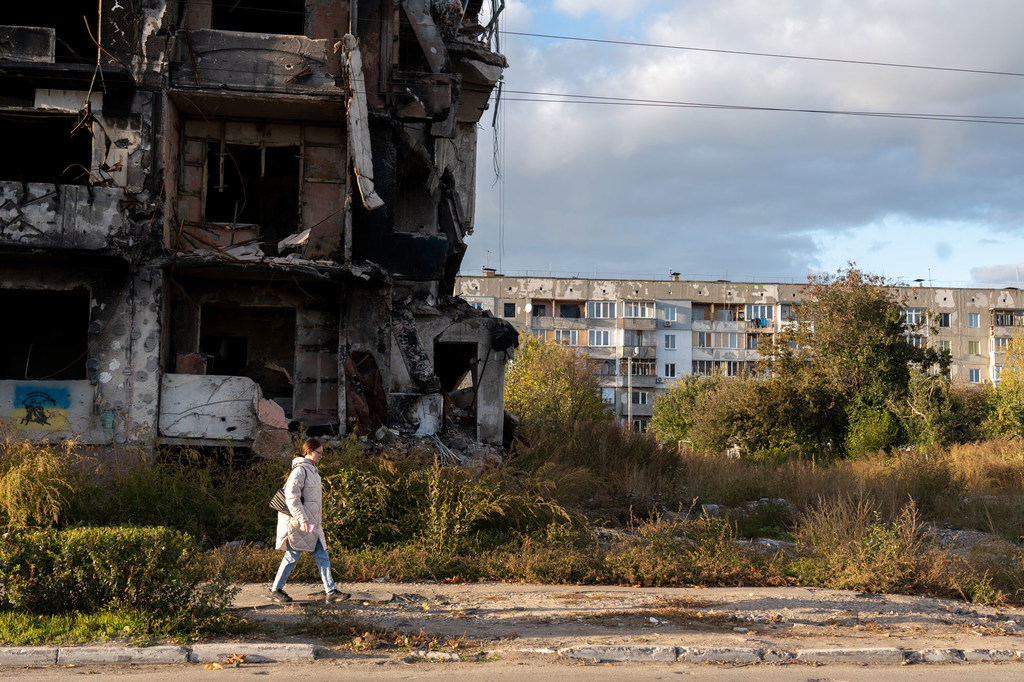 زنی از کنار یک بلوک آپارتمانی ویران شده در غرب اوکراین عبور می کند.